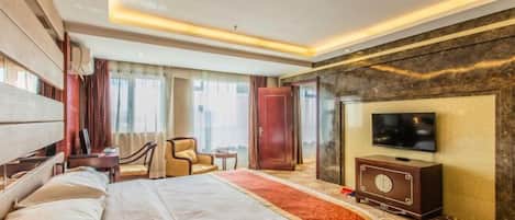 Une chambre d’hôtel avec un grand lit, une télévision, un bureau et une chaise.