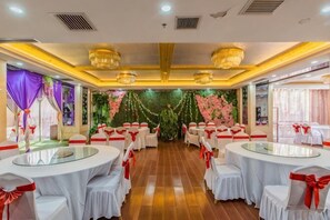 A banquet hall with round tables, white tablecloths, and red sashes. - Taishengyuan Hotel (Shuozhou)