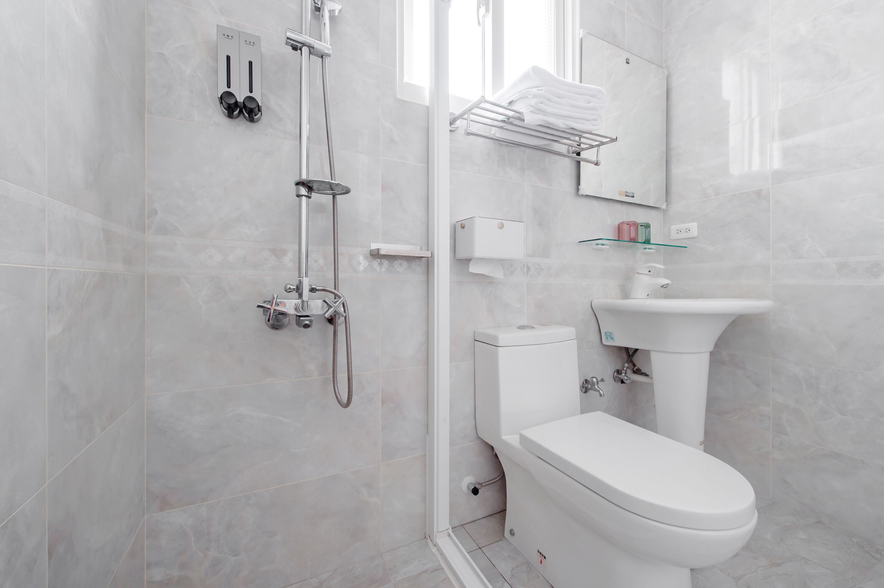 A modern bathroom with a toilet, sink, and shower.