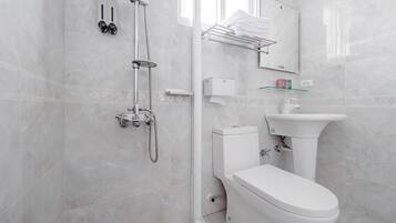 A modern bathroom with a toilet, sink, and shower.