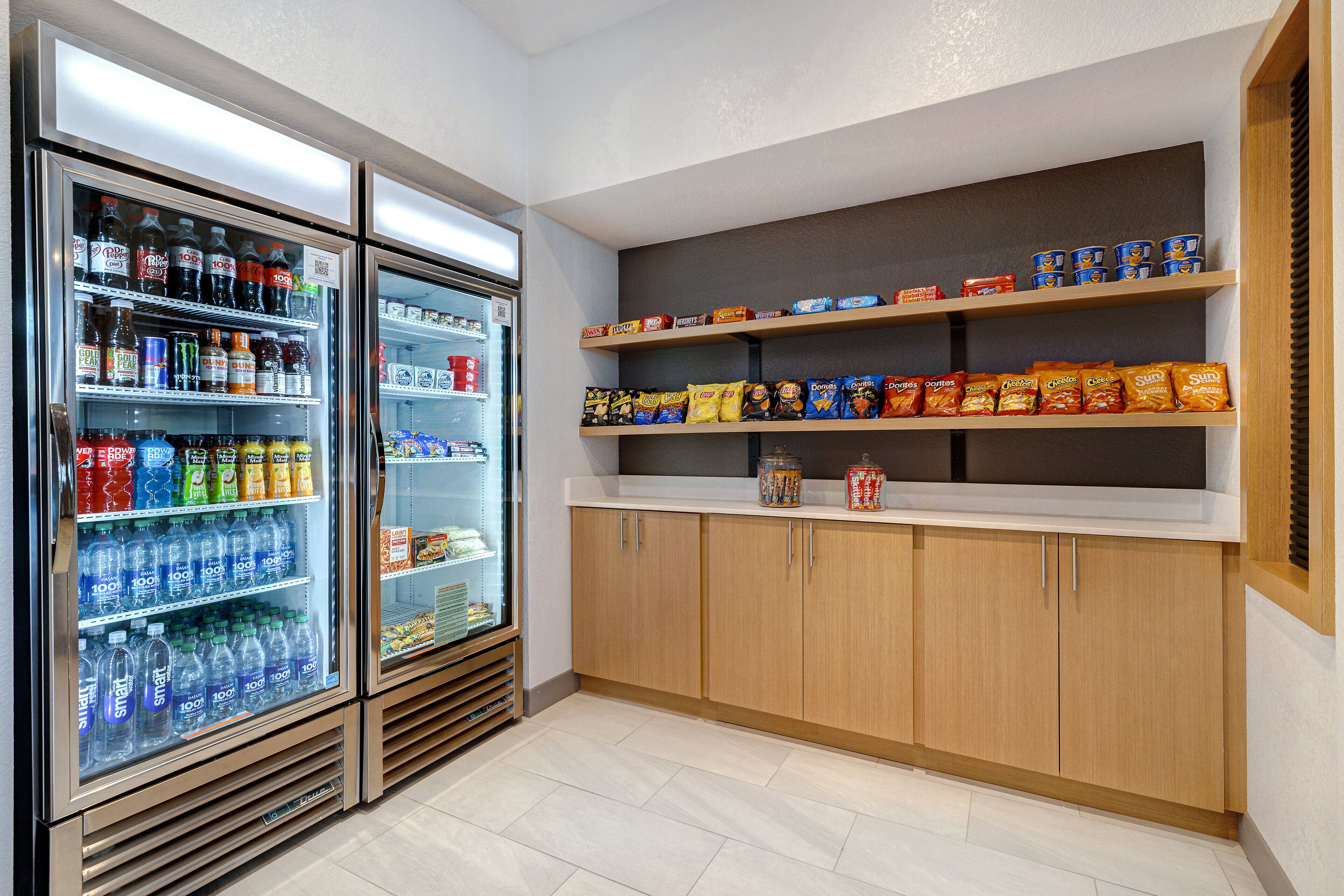 A refrigerated beverage display with various drinks and snacks.