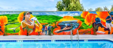 A swimming pool with a mural depicting a golfer and a diver.