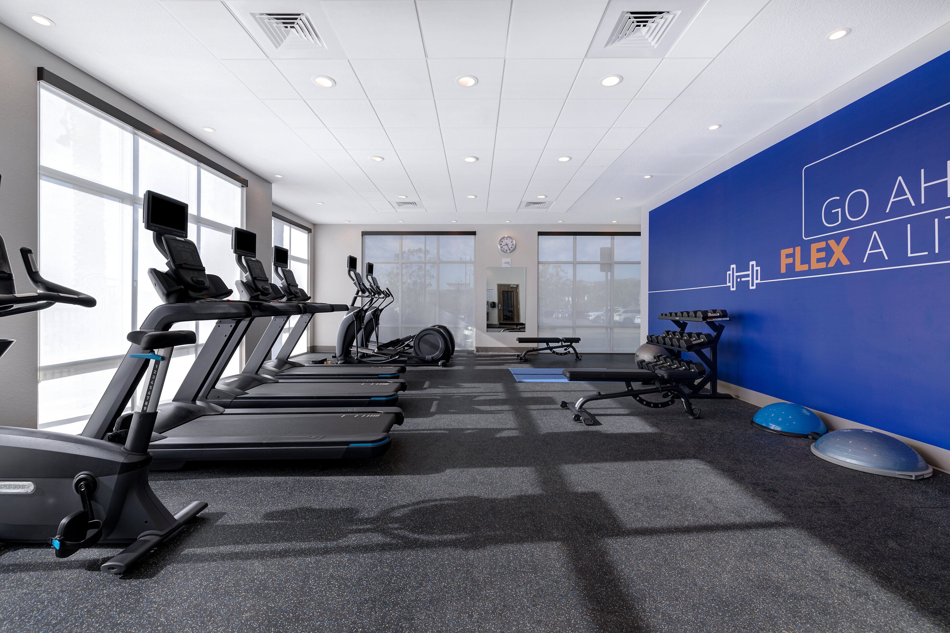 Una palestra moderna con tapis roulant, cyclette e attrezzature per l'allenamento con i pesi.
