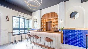 Eine moderne Bar mit einer Holztresen, Barhocker und einer Rückwand aus blauen Fliesen.