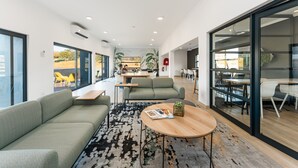 A modern office space with a sofa, round table, and glass partitions. - Ballito Village 69 by HostAgents (Ballito)