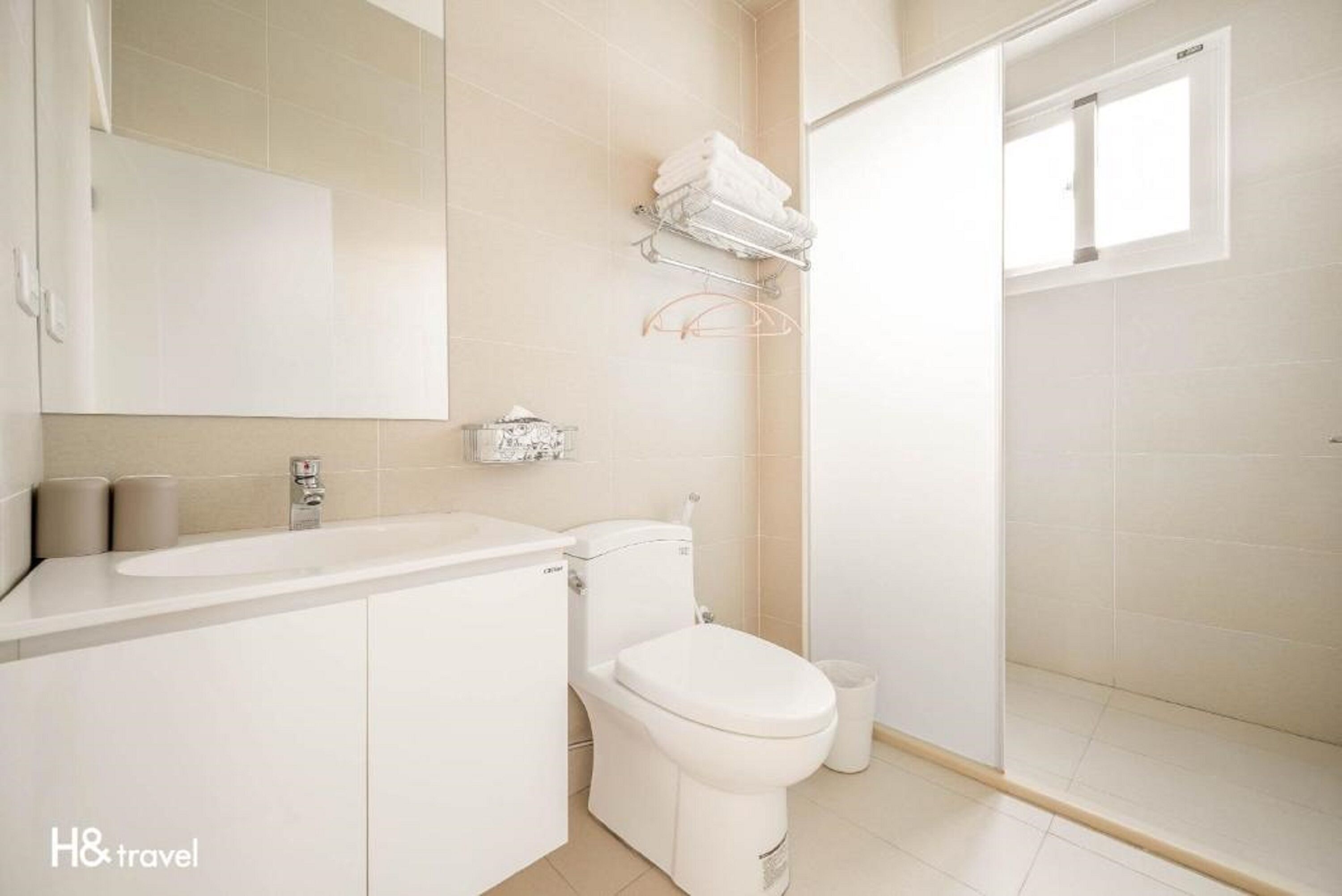 A modern bathroom with a toilet, sink, and shower area.