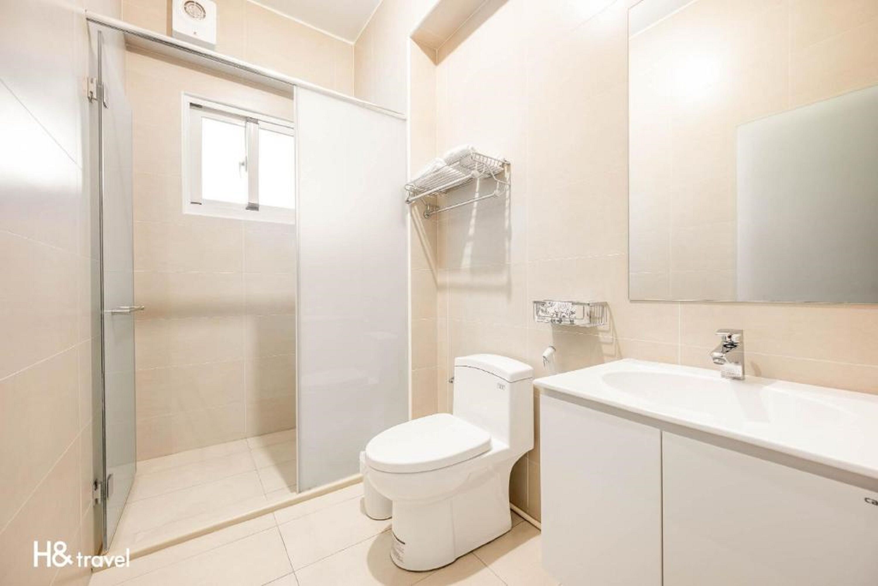 A modern bathroom with a glass shower enclosure, a toilet, and a sink.