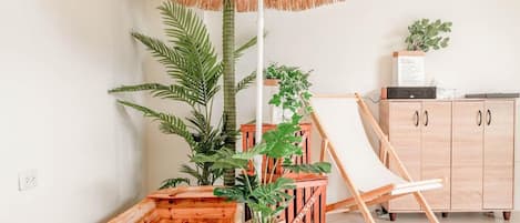 A room with a wooden cabinet, a whiteboard, and a plant.