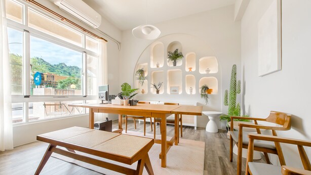 A bright room with large windows, a wooden table, and chairs.