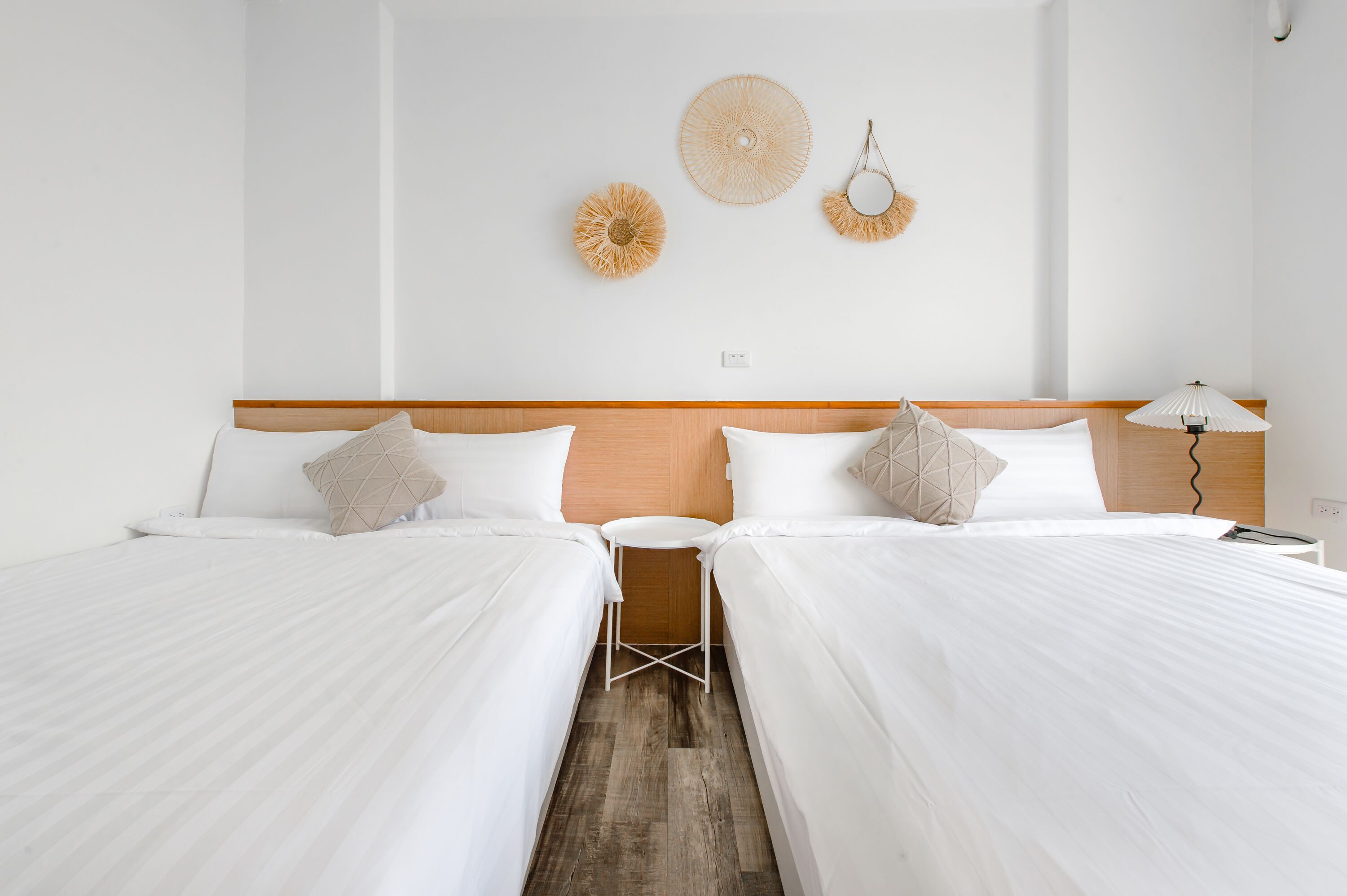 Ein Hotelzimmer mit zwei Betten, einem kleinen Tisch und einer Lampe.