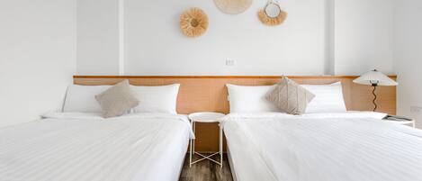 Ein Hotelzimmer mit zwei Betten, einem kleinen Tisch und einer Lampe.