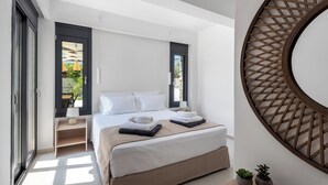A modern bedroom with a bed, bedside tables, a large mirror, and a view of the outdoors.