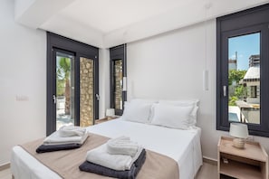 A hotel room with a bed, a nightstand, a lamp, and a view through the window.