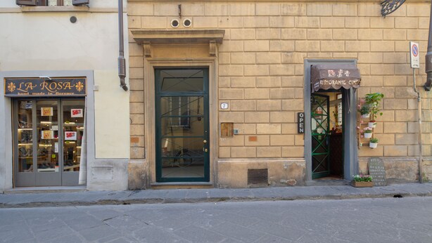 Un edificio con una fachada que muestra el rótulo "LA ROSA" y un restaurante llamado "RISTORANTE CINGI".