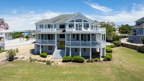 A two-story house with a balcony, a front porch, and a well-maintained lawn.
