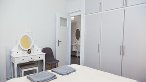 A bedroom with a bed, a vanity with a mirror, a chair, and a wardrobe. - Chic apartment in Athens (Athens)