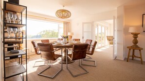 A dining area with a round table, leather chairs, and a wine rack. - Ridgeway Farmhouse at Ragley Estate, Alcester - sleeps 8 guests  in 4 bedrooms (Alcester)