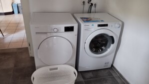 Twee voorladers en een witte wasmand in een wasserij.