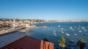 A coastal town with a prominent tower, a marina with boats, and a clear blue sky. - Apartment 'Cascais Bay Terrace IV' with Sea View & Wi-Fi (Cascais)