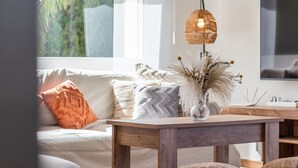 En stue med en sofa, et træbord og en dekorativ vase med tørrede planter.