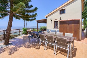 Une terrasse avec une table et des chaises, une porte en bois et une vue sur le paysage.