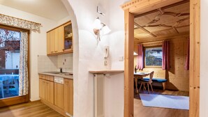 Un interno in legno con cucina, zona pranzo e vista da una finestra.