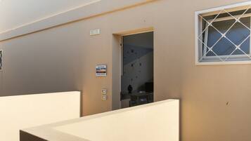 A hotel room with a bed, a window, and a door leading to a bathroom.