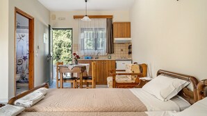 Ein Schlafzimmer mit einem Bett, einem Nachttisch und Blick zur Küche.