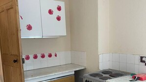 Uma cozinha compacta com armários de madeira, fogão a gás e forno embutido.