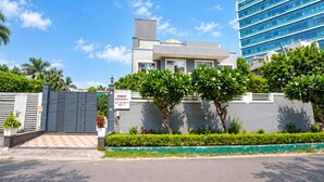 A modern building with a gated entrance, a sign indicating 'ENKAY RESIDENCY,' and a clear blue sky. - Enkay Residency Sector 15 (Gurugram)