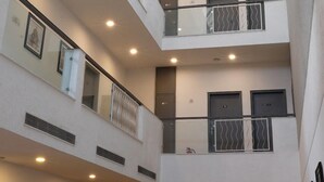 A multi-level atrium with a glass ceiling, multiple floors, and balconies. - Enkay Residency Sector 15 (Gurugram)