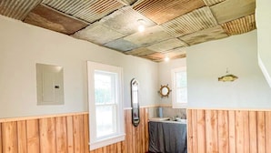 A room with wooden paneling, a wooden floor, a sink, and a mirror. - Cozy private Lakehouse with prime fishing, hunting, and lake access. (Webber)