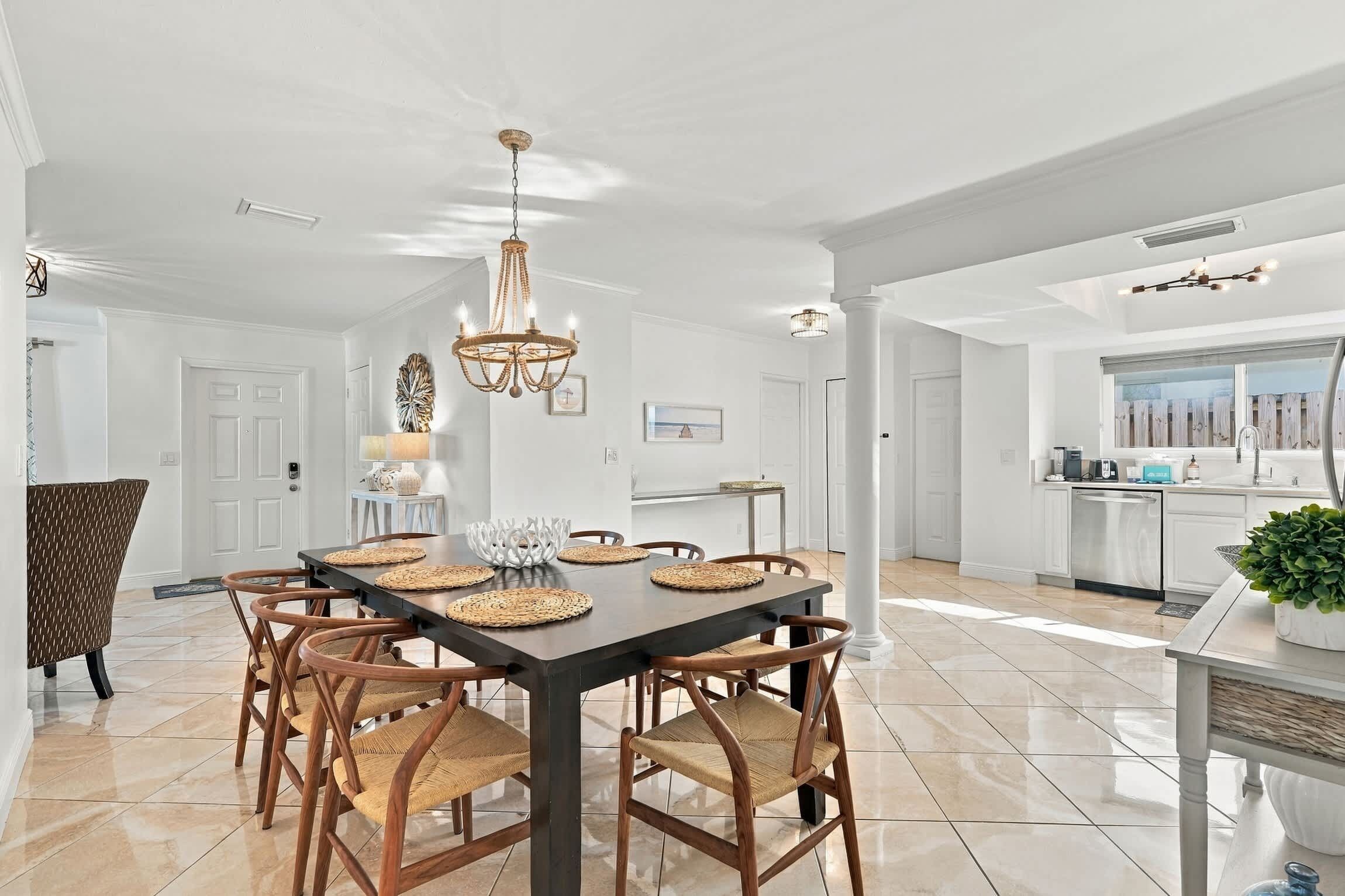 A spacious dining area with a dark wooden table, woven placemats, and wicker chairs.