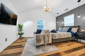 A bedroom with a bed, bedside table, and a large window. - Harmony House, Sleeps 8 (Decatur)