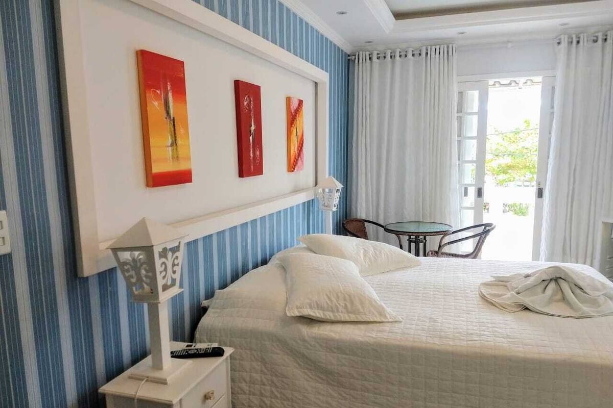 Ein Hotelzimmer mit Bett, Schreibtisch und Stuhl. Über dem Bett hängen drei Bilder an der Wand.