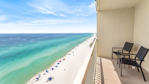 A balcony with a view of a beach and ocean.