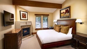 A bedroom with a large bed, a fireplace, a television, and artwork on the walls. - Two Bedroom Suite 2 Apartment Hotel by RedAwning (Park City)