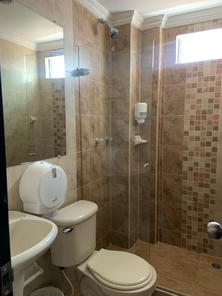 A bathroom with a shower, toilet, and sink.