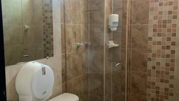 A bathroom with a shower, toilet, and sink.