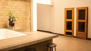 A bathroom with a large sink, two wooden doors, and a potted plant. - Hotel Andinos Plaza (Pitalito)