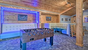 Un espacio interior acogedor con una mesa de fútbolín, un banco acolchado y un sofá.