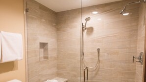 Un baño moderno con ducha de vidrio, inodoro y perchero para toallas.