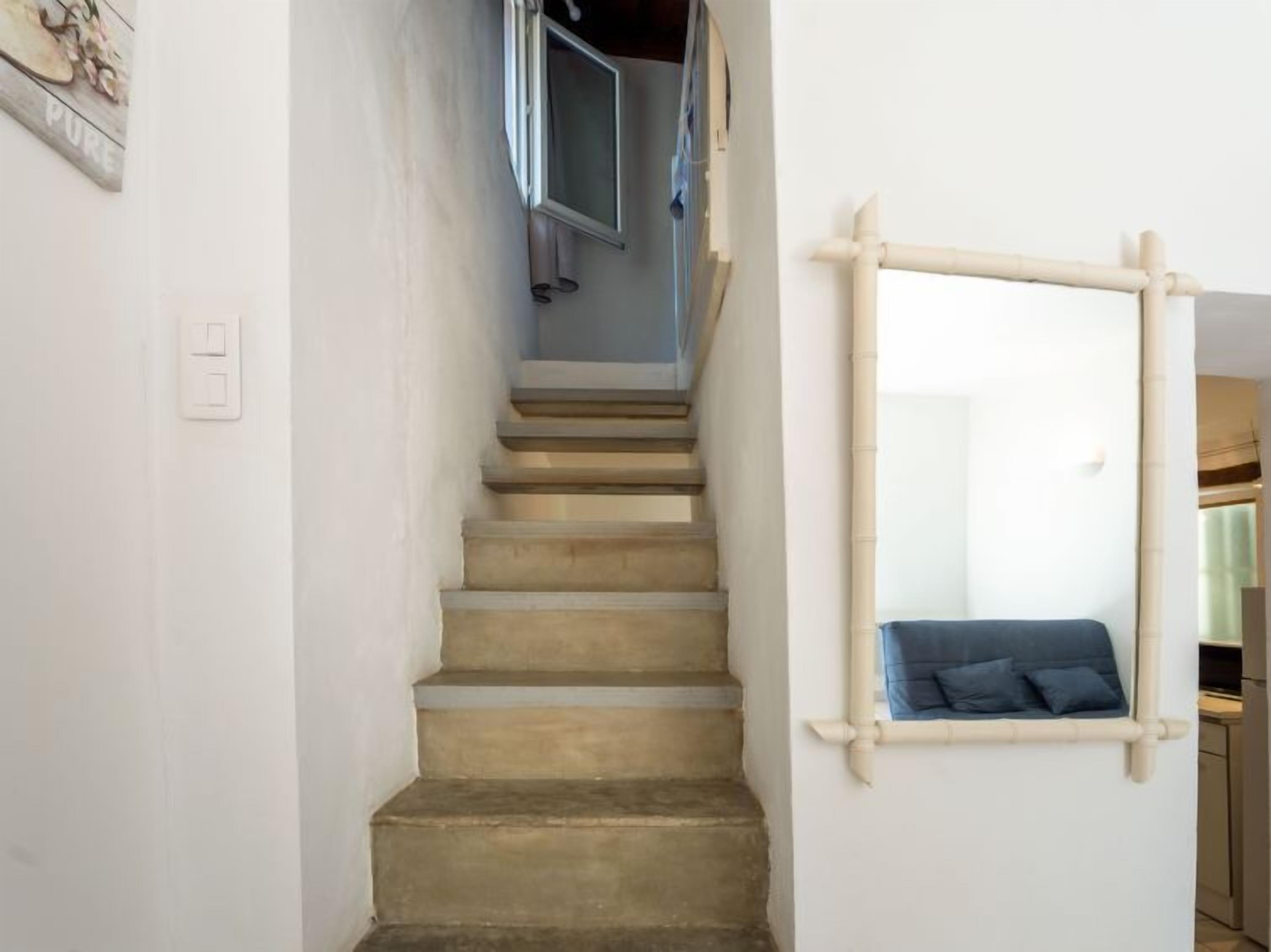 Eine Treppe mit Handlauf und einem an der Wand befestigten Spiegel.