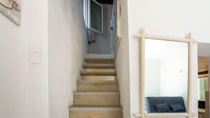 Una scala con corrimano e uno specchio fissato al muro.