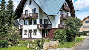 A two-story chalet with a steeply pitched roof, wooden balconies, and a well-maintained garden. - Alice II. by Interhome (Harrachov)