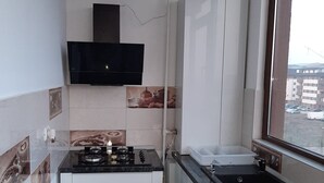 A compact kitchen with a gas stove, a built-in oven, and a sink. - Stunning Green Studio 43 (Chiajna)