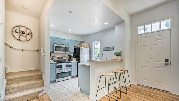 Une cuisine moderne avec des meubles de couleur bleu clair, un îlot central et un escalier en bois.