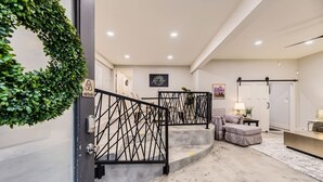 A modern interior with a staircase, a living area, and a hallway.