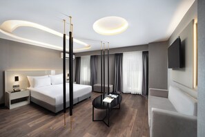A modern hotel room with a large bed, a bedside table, a flat-screen TV mounted on the wall, and a small side table. - Pianoforte by Febor Hotels & Spa (Istanbul)