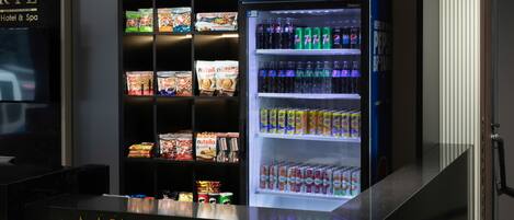 Um minimercado com um refrigerador de Pepsi e prateleiras repletas de lanches e bebidas.